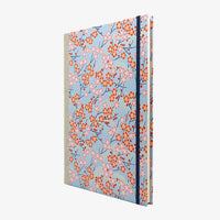 Notizbuch-A4-liniert-160Seiten-Cover-chiyogami-Motiv-Pflaumenblueten-pink-auf-hellblau-seitlich-von-vorn