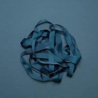 Ripsband-Breite-16mm-laenge-5m-Farbe-Petroblau-Ausgerollt-auf-farbigen-untergrund-Produktansicht-1