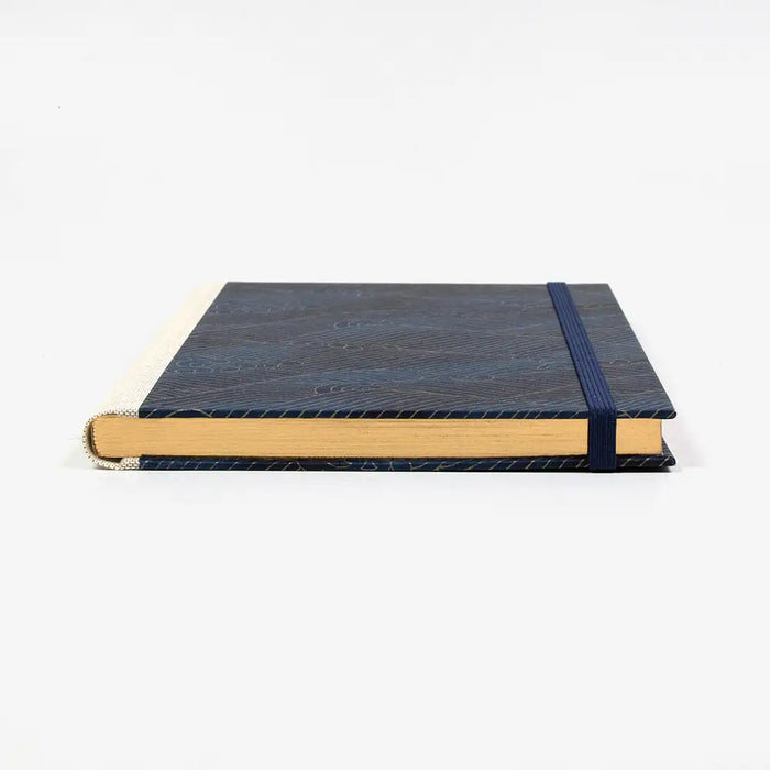 Skizzenbuch-A5-mit-Goldschnitt-cover-chiyogami-Papier-160-Seiten-Motiv-Welle-Gold-auf-blau-liegend