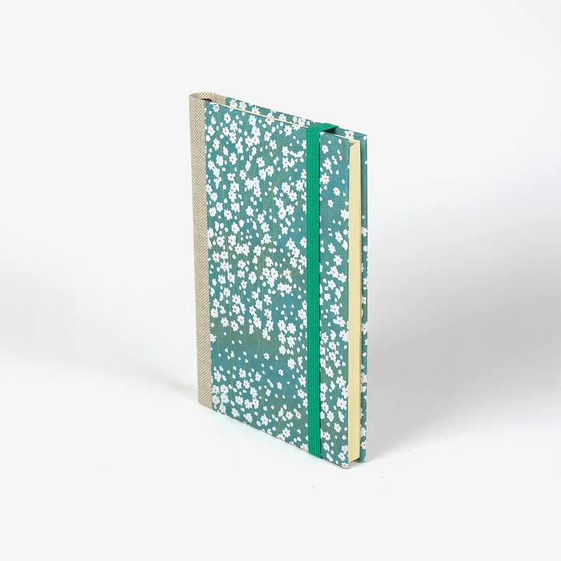 Wochenplaner-2026-blaupause-format-9x13cm-bezogen-mit-chiyogami-kleine-weisse-Blueten-am-Busch-auf-hellblau-Produktansicht-cover-seitlich-vorn