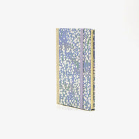 Wochenplaner-klein-9x13cm-mit-chiyogami-bezogen-muster-kleine-weisse-Blueten-am-Busch-auf-blau-cover-seitlich-von-vorn
